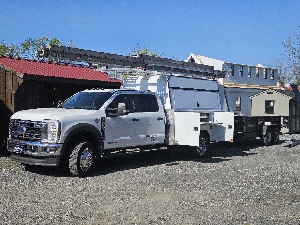 White Pine Structures Ford F-550 crew cab service truck with ladder rack, utility bed, and dump trailer at the Parkesburg lot